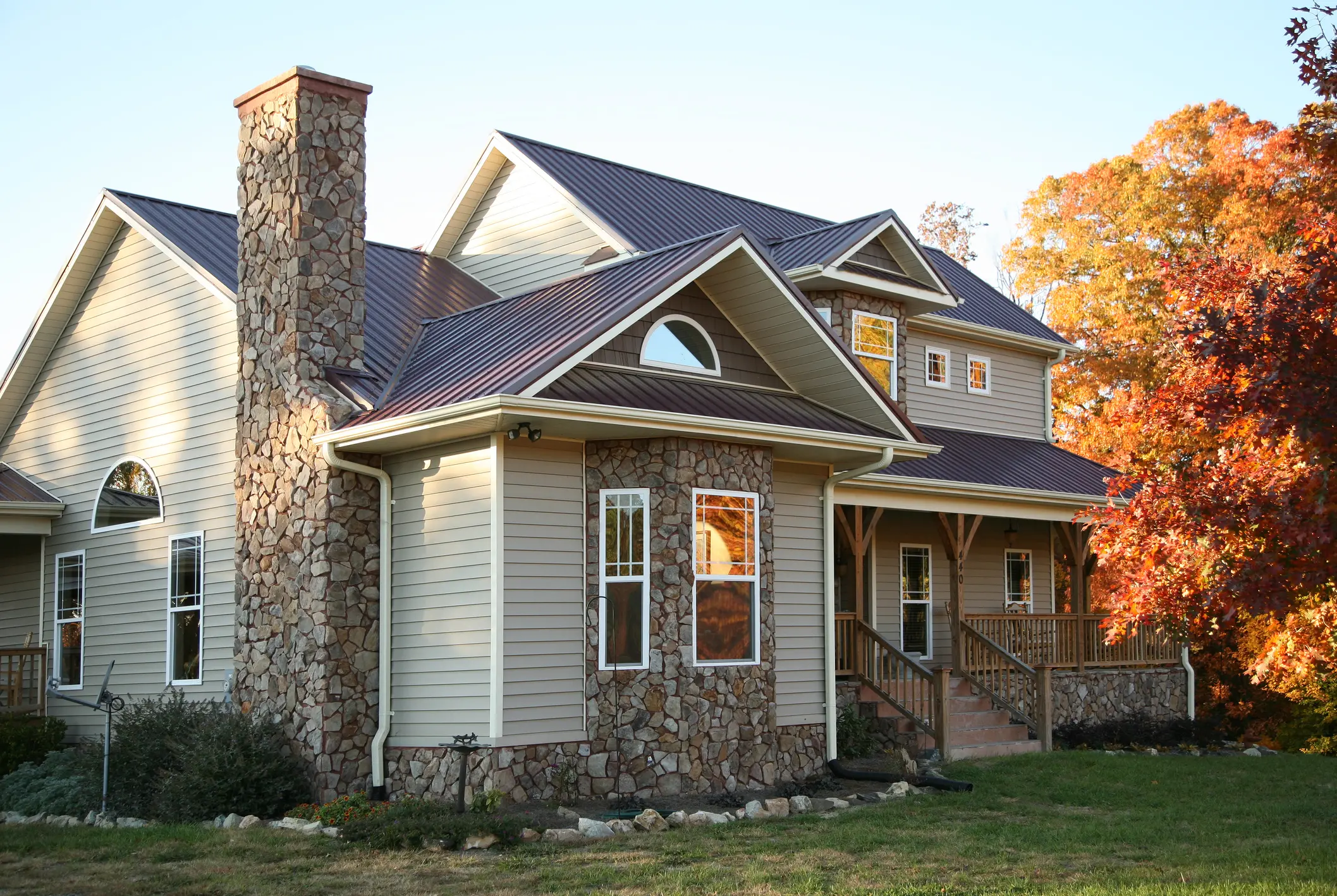Residential home with stone siding and standing seam metal roof for Brush Prairie, WA metal roofing services.