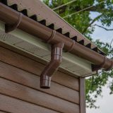 Gutter with downpipe on the roof a house.